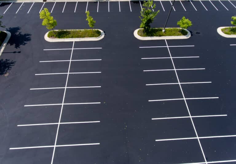 parking lot,asphalt,island,trees,stalls,parking stalls,paint,green